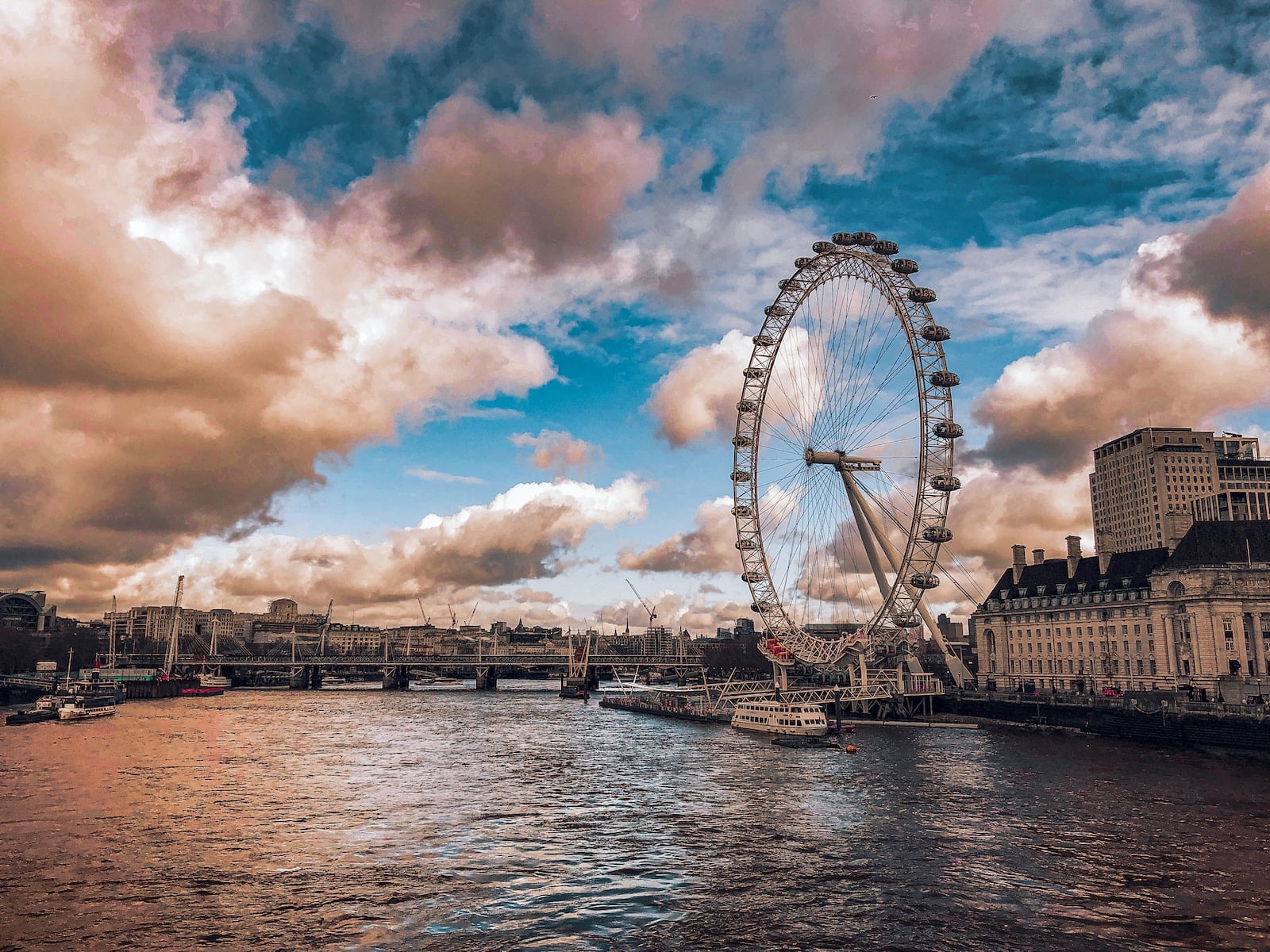 ferris wheel beside body of water under cloudy sky during daytime